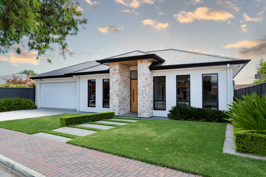 Happy homeowners in front of their newly built double-storey home