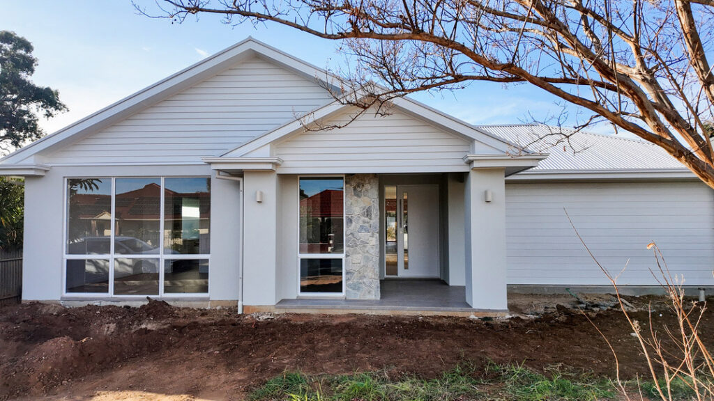 A satisfied homeowner enjoying their newly built, high-quality house